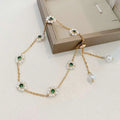 Emerald pearl flowers bracelet featuring a delicate gold chain with white pearl flowers and green gemstones, adjustable chain