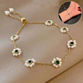 Gold-toned emerald pearl flowers bracelet with five floral motifs and adjustable chain featuring white pearls