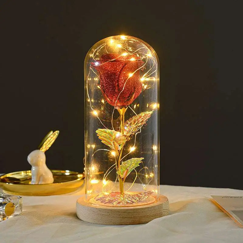 Eternal rose LED light featuring a glittering red rose with gold leaf stem in an elegant glass dome romantic gift