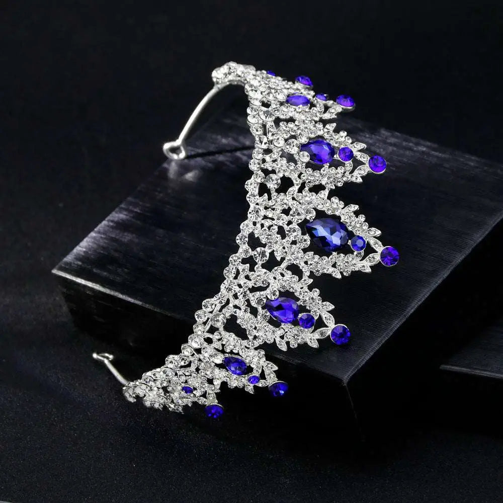 A sparkling silver bridal crown with intricate lace metalwork featuring deep blue teardrop crystals european style