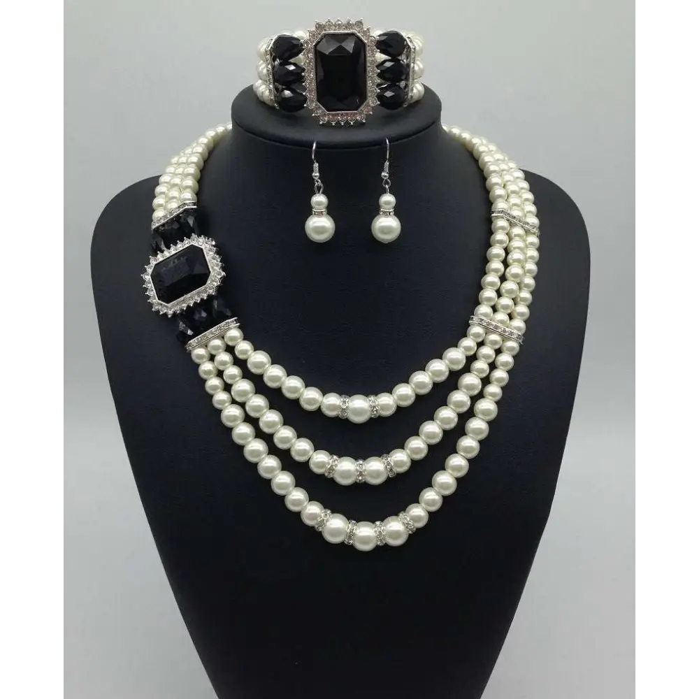 Elegant european fashion diamond gemstone pearl jewelry set featuring a three-strand pearl necklace with onyx accents and matching earrings and bracelet