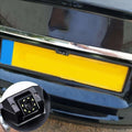 Black plastic european night vision camera with circular lens and yellow led lights mounted on car rear side