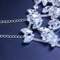 A sparkling silver chain necklace with clear marquise-cut crystals for an exaggerated fashion rhinestone mask