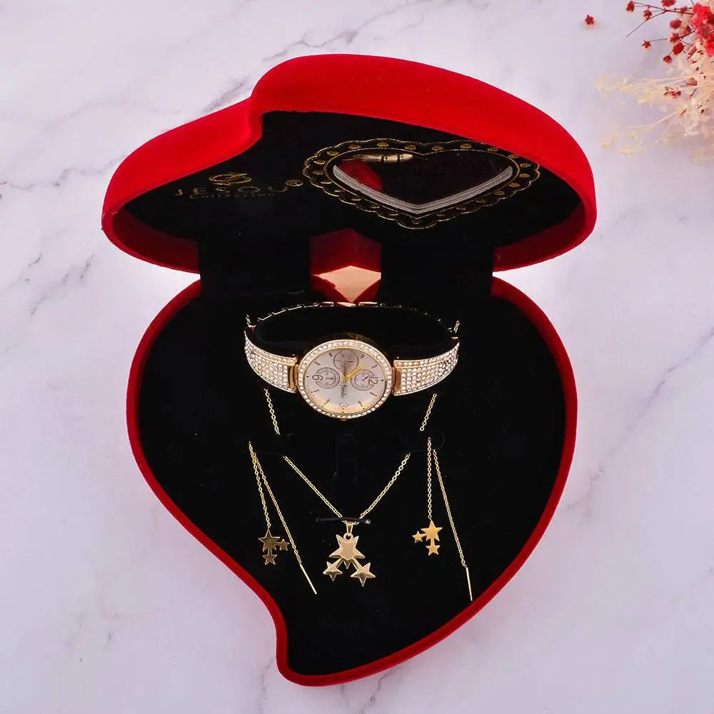Exquisite jewelry watch with gold-toned diamond band and matching star necklaces in red velvet heart-shaped box