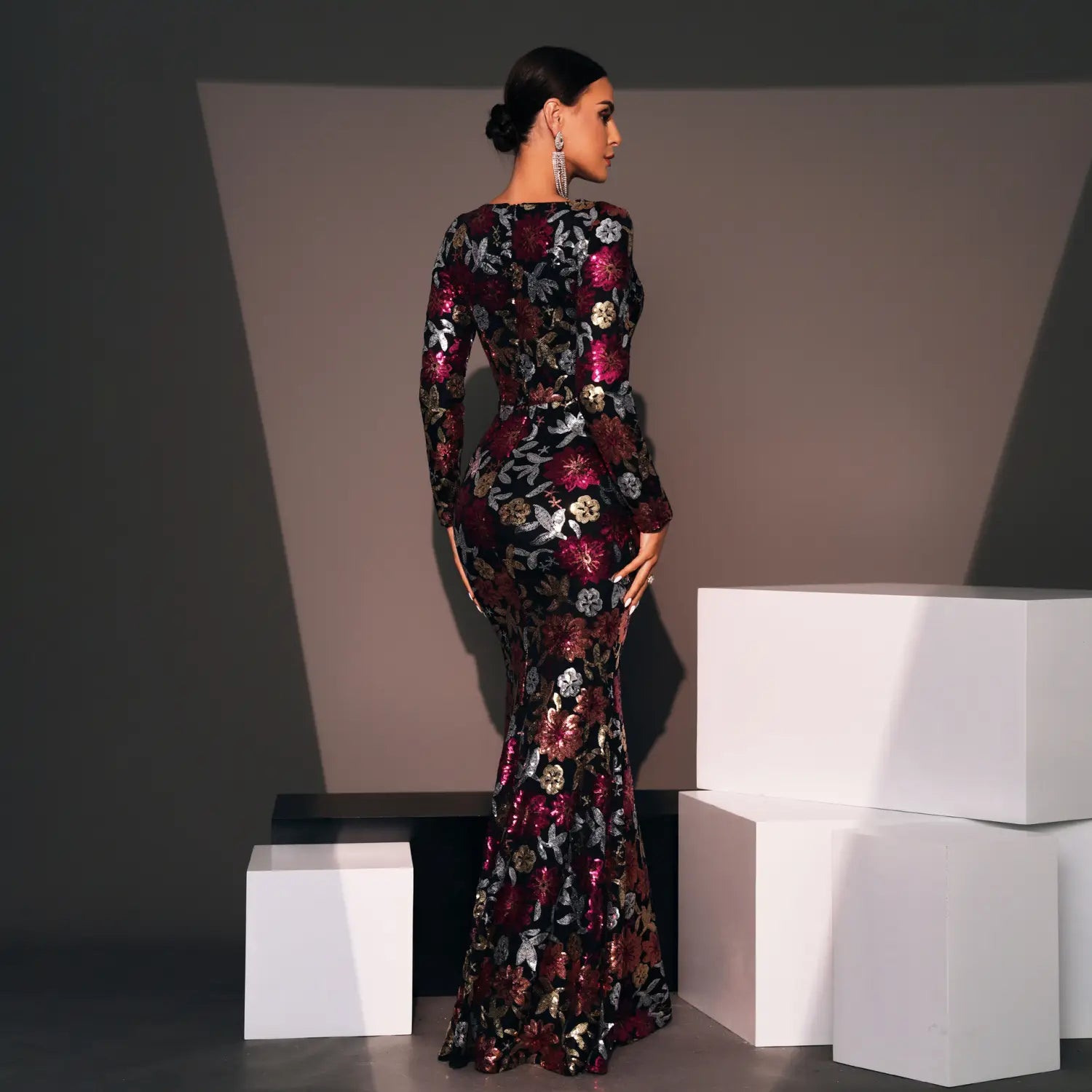 Embroidered floral long sleeve evening gown in deep burgundy and black featuring a mermaid cut and metallic accents.