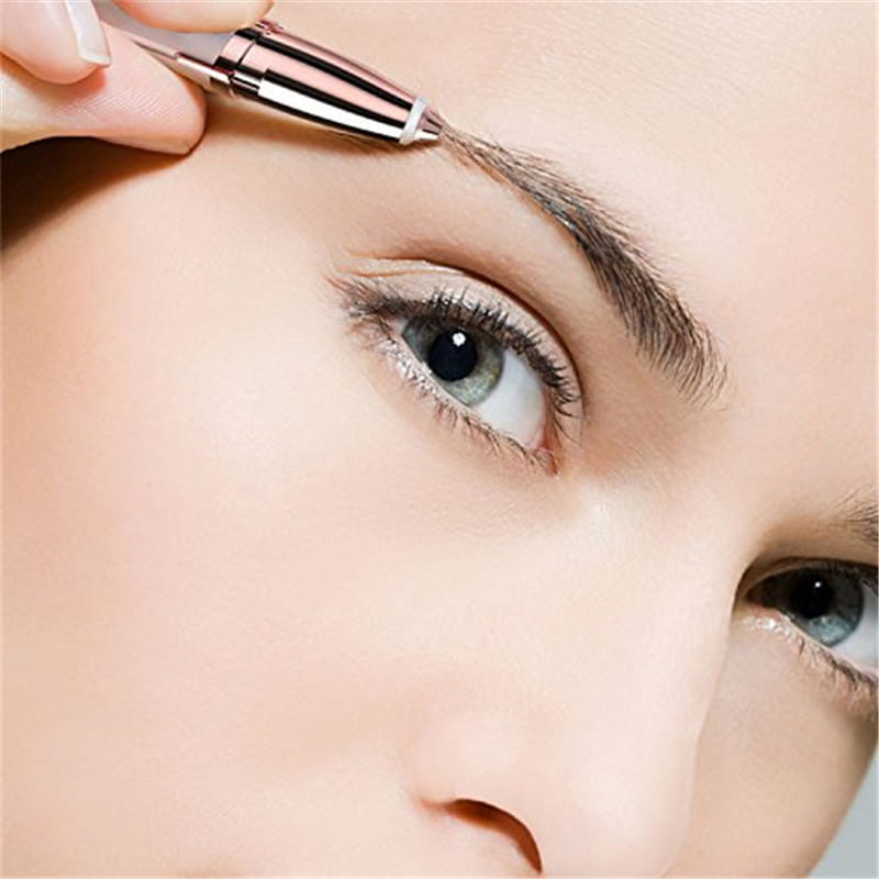 a sleek rose gold and silver flawlessly brows electric eyebrow remover with a fine tip being used to groom an eyebrow