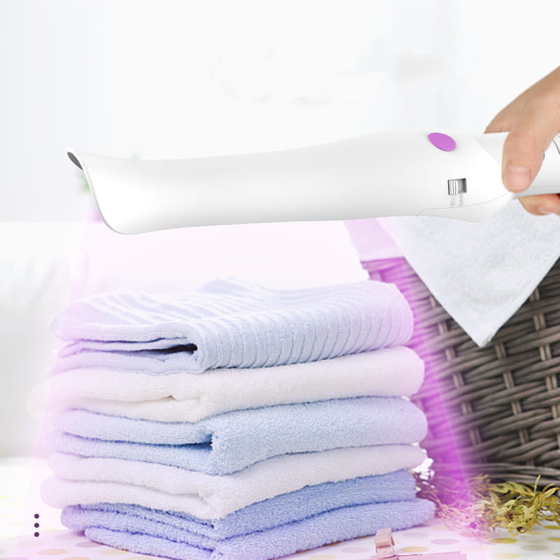 White handheld garment steamer with purple power button and silver nozzle featured in an ergonomic travel sterilization lamp stick for effective sterilization and portability.