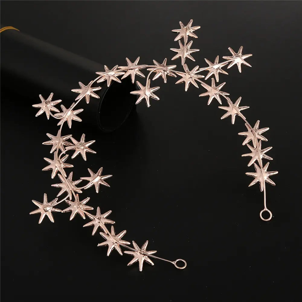 A delicate rose gold star-shaped hair band adorned with sparkling five-pointed stars connected by slender metallic wires serves as elegant accessories starry hair.