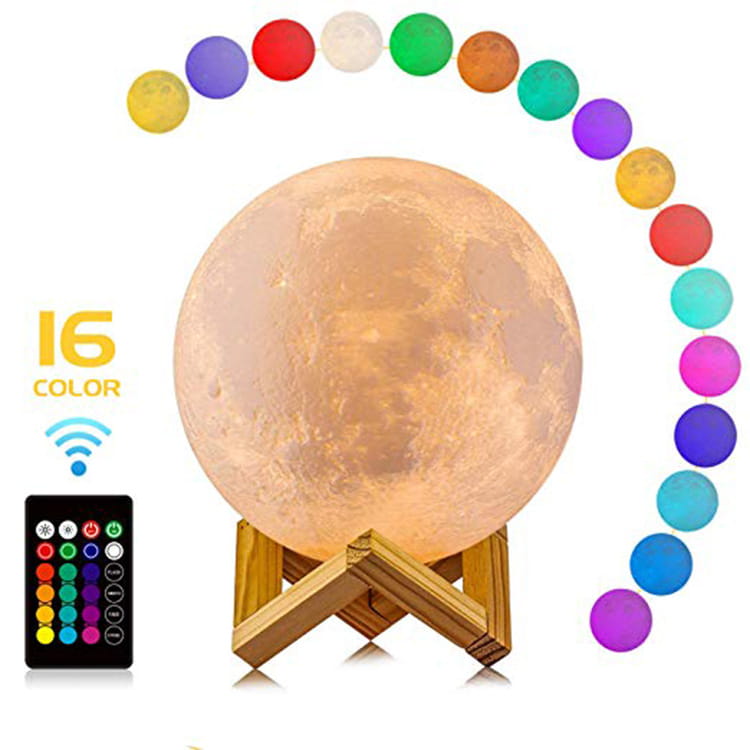 A warm illuminated moon night table lamp with a realistic lunar surface texture on a wooden stand featuring a remote control for 16 color settings.