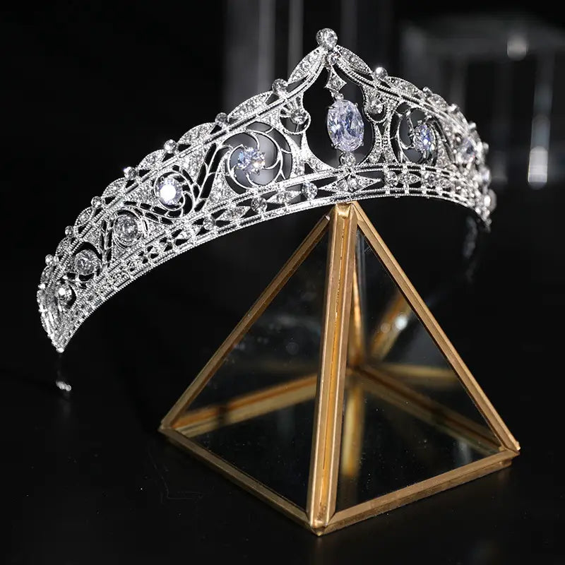 an ornate silver filigree bridal crown with sparkling clear crystals and three prominent oval-shaped stones designed for wedding makeup european-style looks