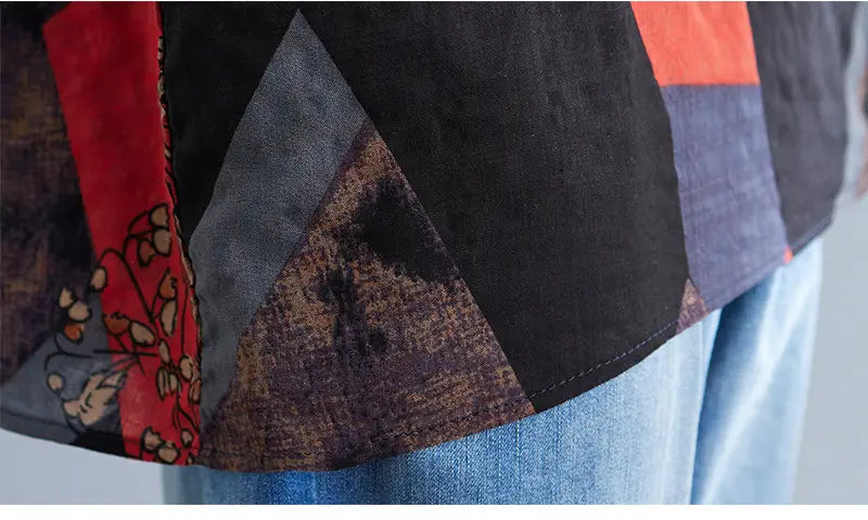 A stylish loose round neck printed patchwork blouse featuring bold geometric panels in black red and muted earth tones with a floral print section.