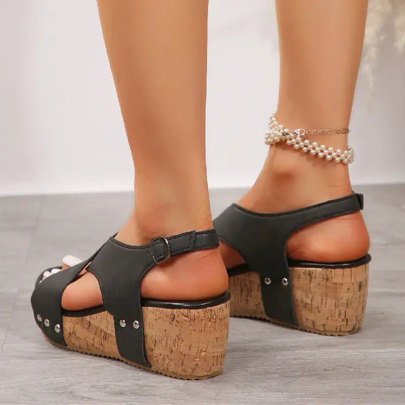 black leather rivet wedges snadals with cork soles and silver studs featuring a fish mouth design