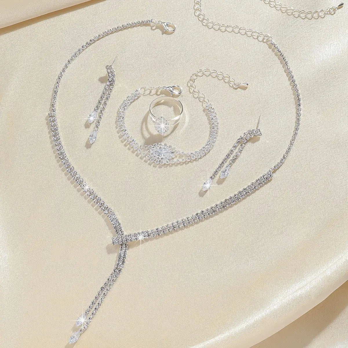 Silver rhinestone fashion simple necklace earring bracelet set featuring a sparkling bridal necklace, matching earrings, bracelet, and ring with intricate crystal detailing.