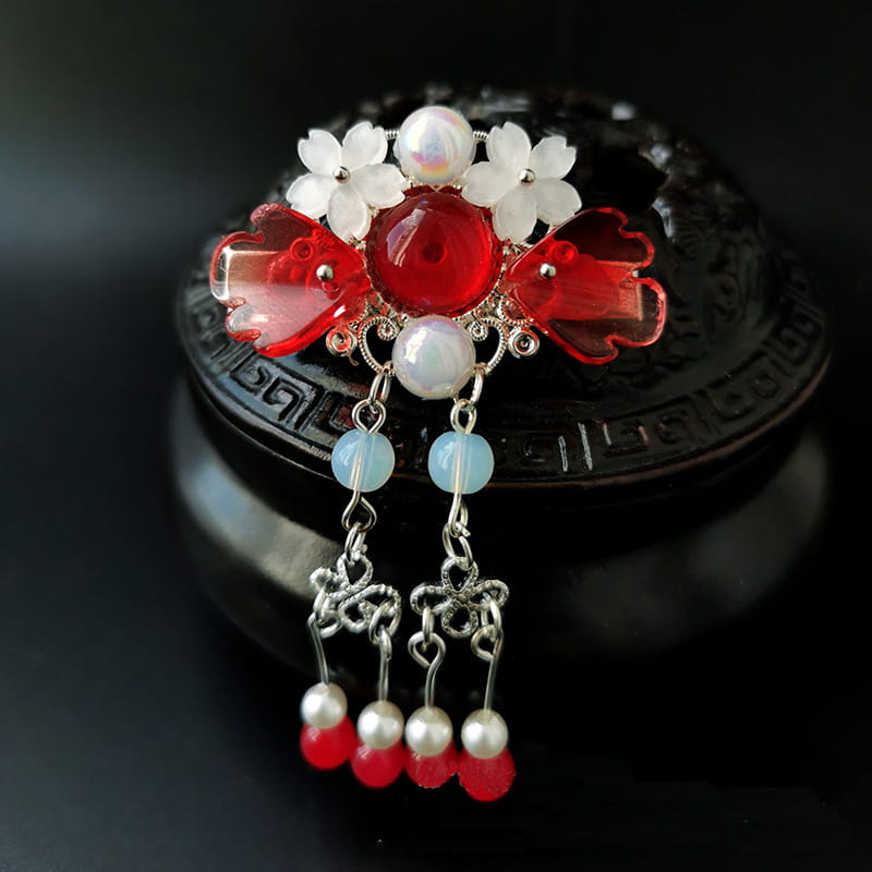 pink floral retro headgear girls hairpin featuring a delicate red and white floral design with translucent gemstones, silver filigree, and dangling pearl and red bead charms.