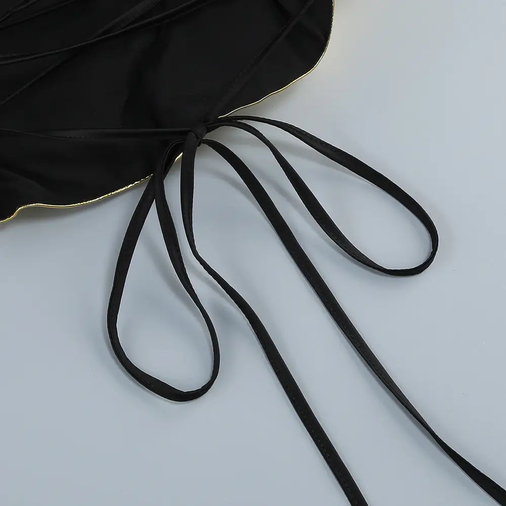 black satin one-shoulder slit mop black top with gold-trimmed edges and matching tie strings from a two-piece mop black dress set featuring sexy lacing details