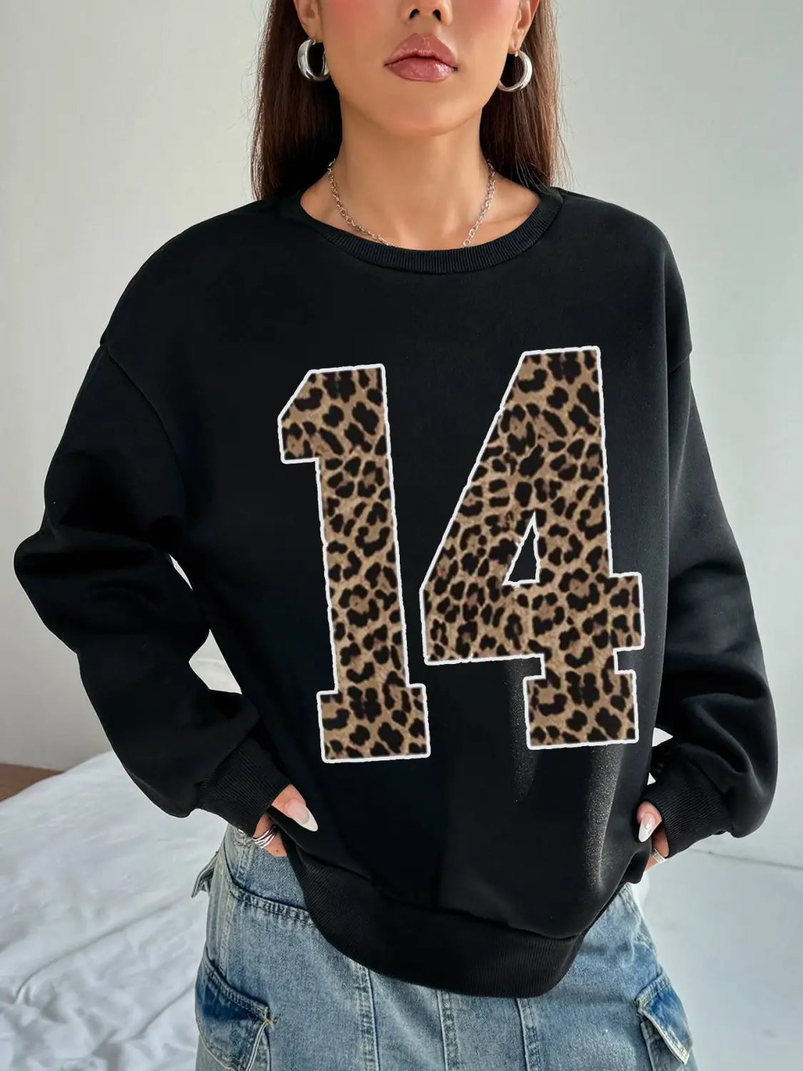 black crew neck sweatshirt featuring a bold leopard print number 14 with white trim on the front