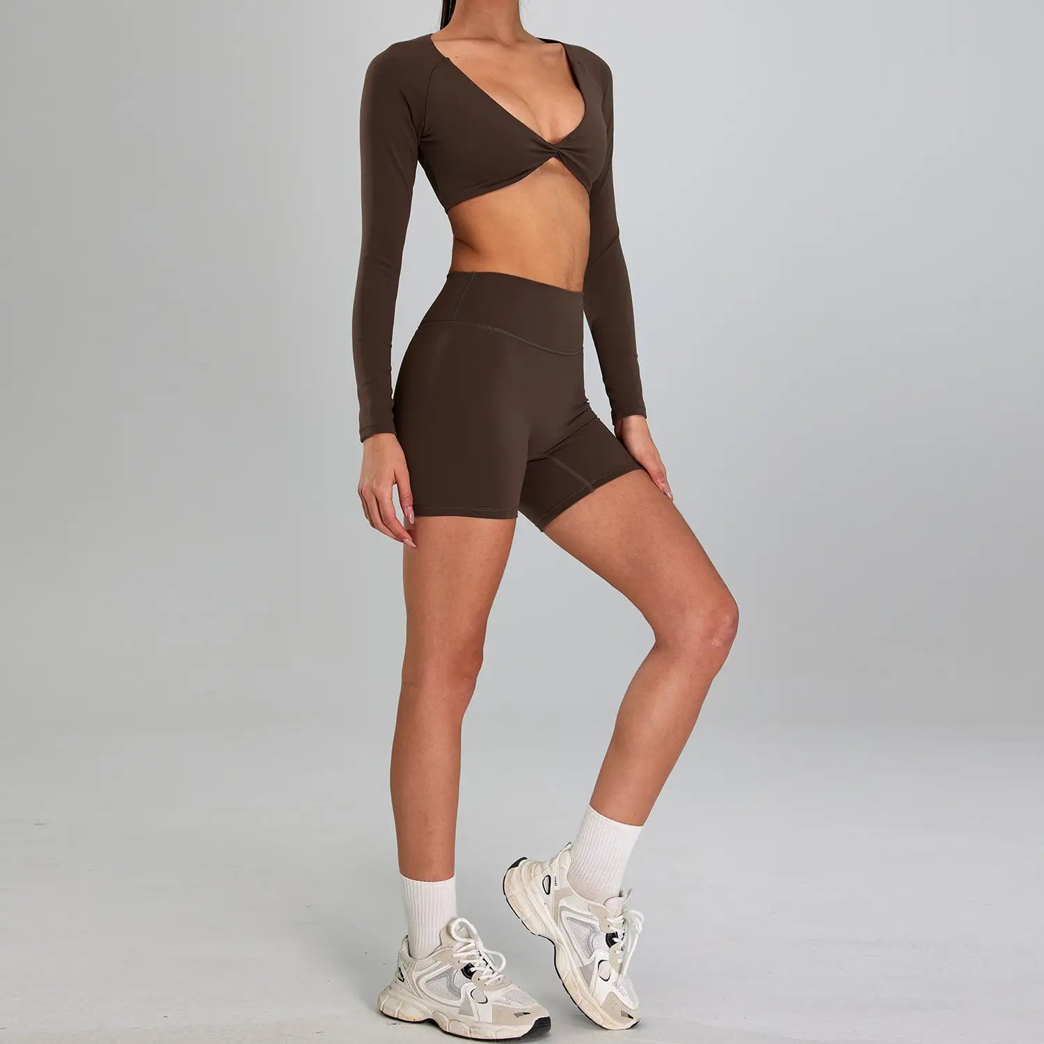 brown long-sleeved crop top with twisted front detail and matching high-waisted shorts in a maroon high waist suit outdoor running nude set designed for sports suit outdoor activities.