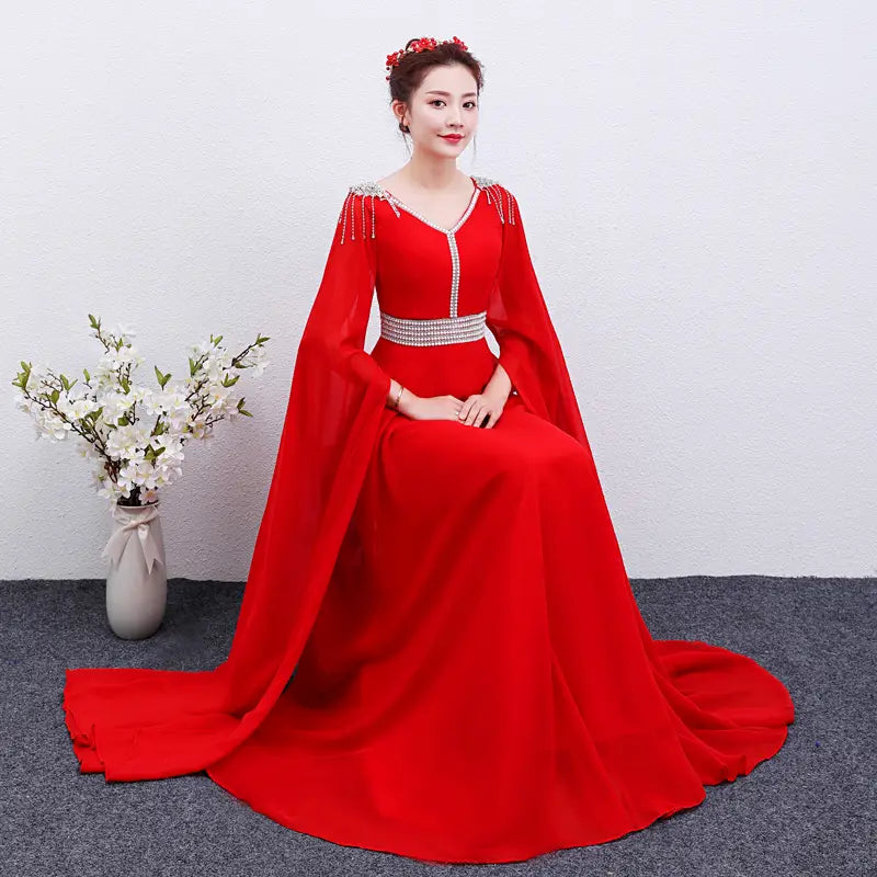 A vibrant red long guzheng performance dress featuring a floor-length design with long flowing sleeves and a v-neckline adorned with sparkling embellishments along the shoulders and waistband.
