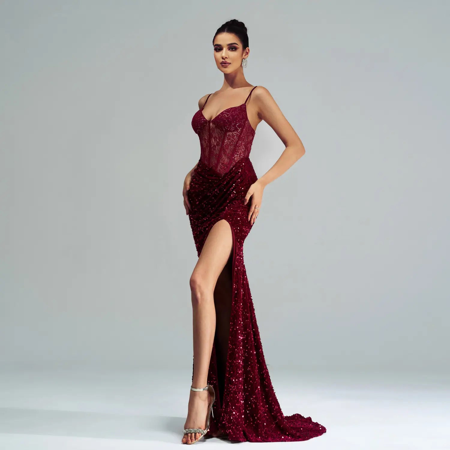 A burgundy sleeveless sequined high slit evening dress featuring a fitted bodice and shimmering sequins perfect for formal occasions.
