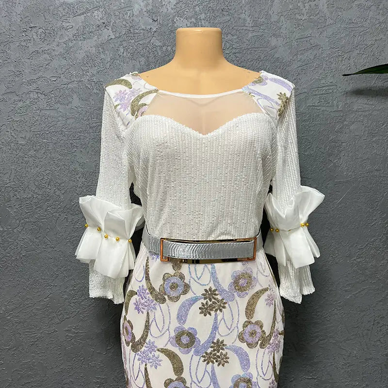 White sequined half sleeve slim fit evening dress with floral embroidery round neck and silver belt accents.