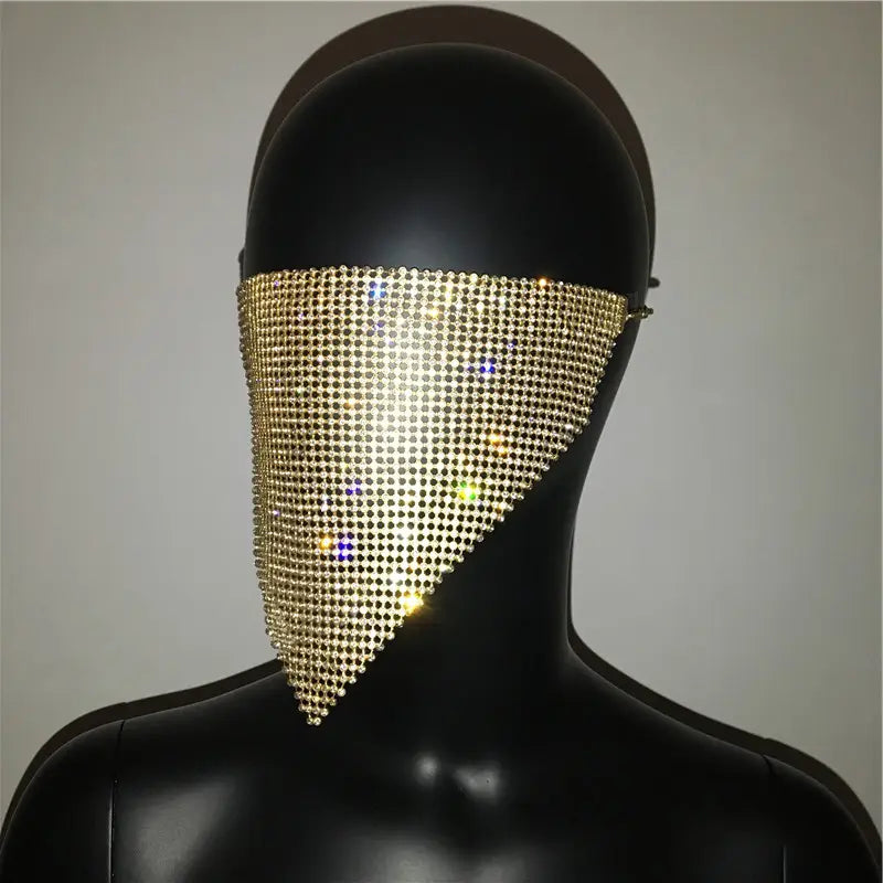 a shimmering gold rhinestone face veil with a triangular mesh design featured as an explosive metal flash jewelry mask