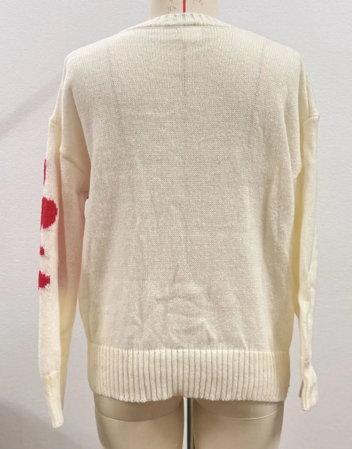 cream-colored knit christmas 3d floral sweater featuring a red heart pattern on the left sleeve and floral contrast color crewneck design