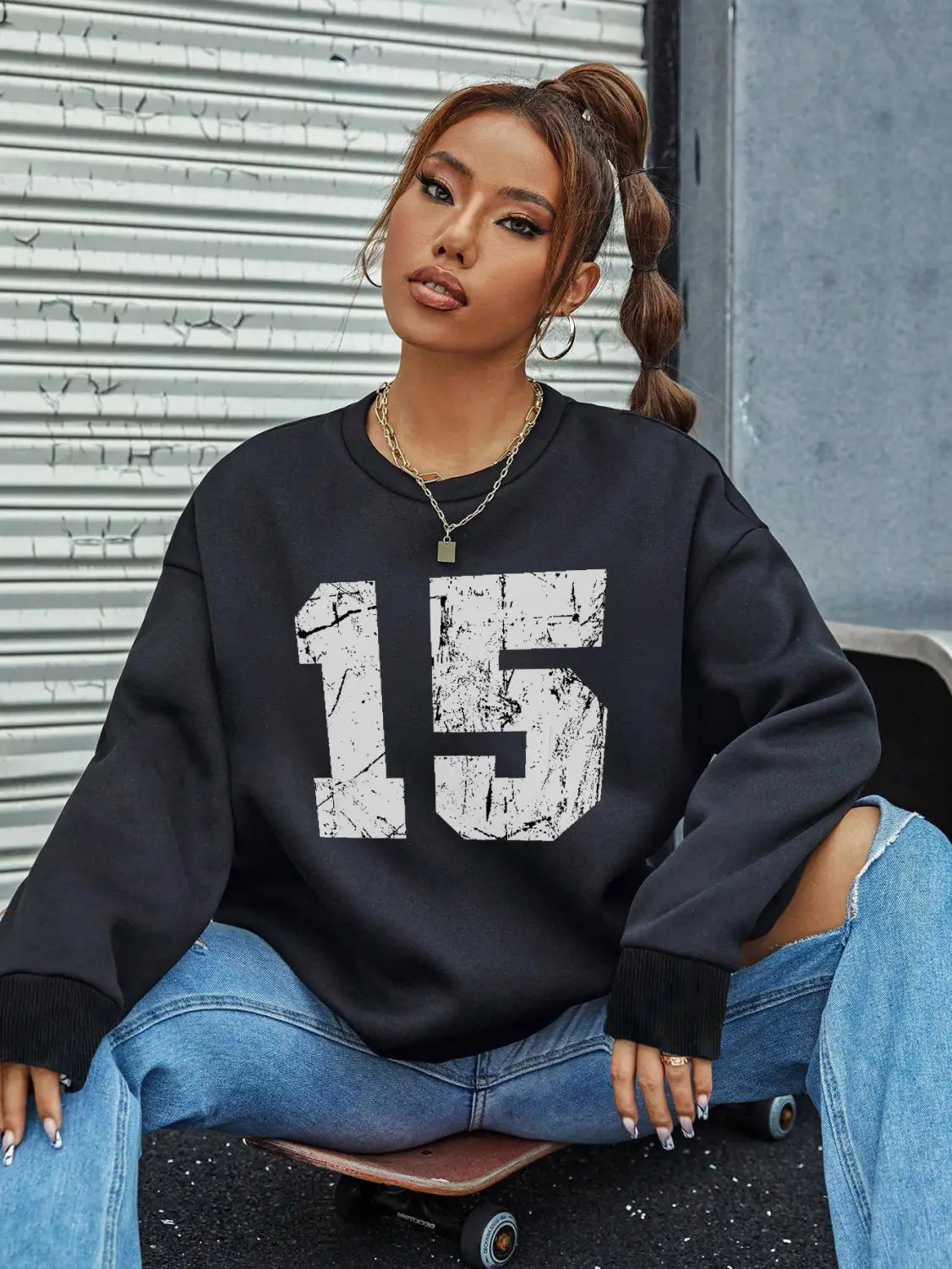 Black oversized crew neck sweatshirt featuring a distressed white number 15 graphic on the front.