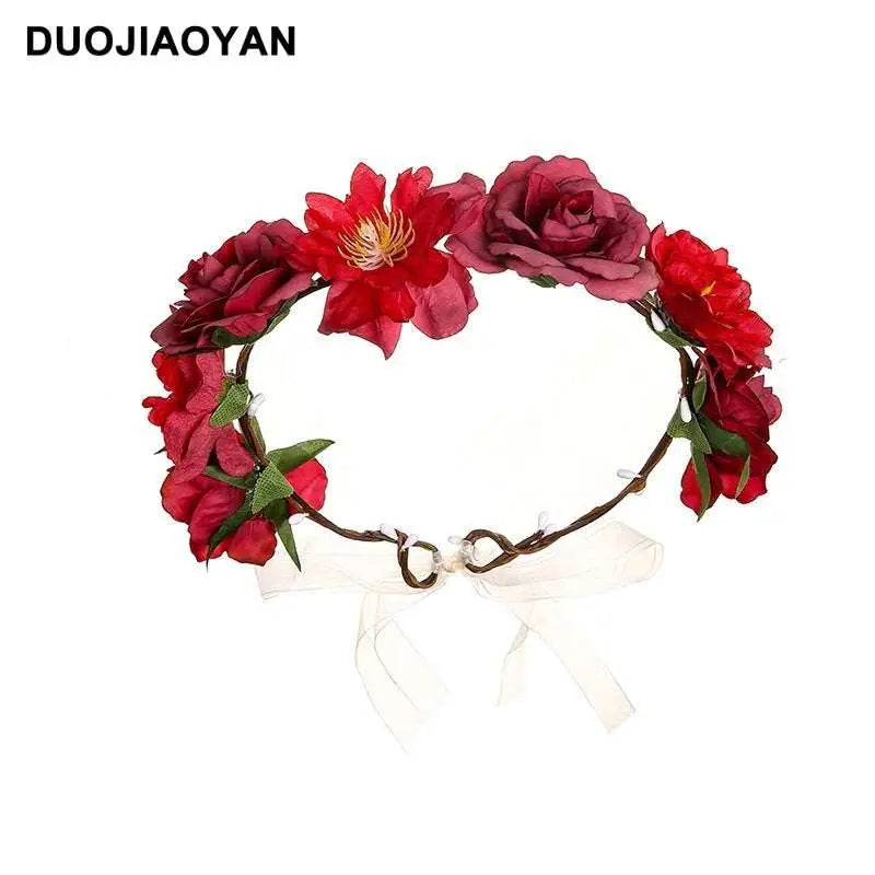 A fabric colorful rose flower garland hair accessory with red artificial roses, green leaves, and a white ribbon bow
