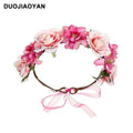 A delicate fabric colorful rose flower garland hair accessory with pink and white blooms and a sheer ribbon bow