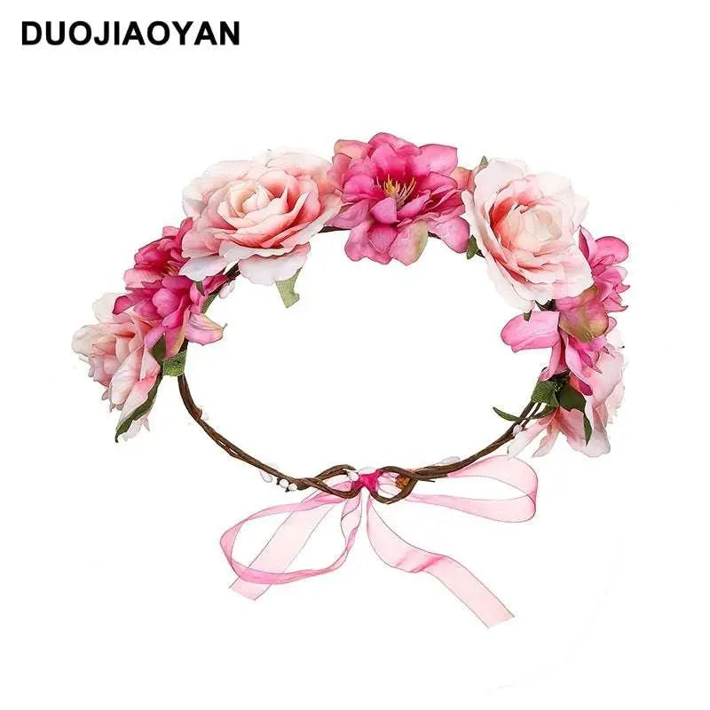 A delicate fabric colorful rose flower garland hair accessory with pink and white blooms and a sheer ribbon bow