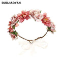 A delicate fabric colorful rose flower garland hair accessory with pink and white blooms and a sheer ribbon bow