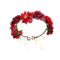A fabric colorful rose flower garland hair accessory with red and burgundy artificial roses and green leaves tied by a white ribbon
