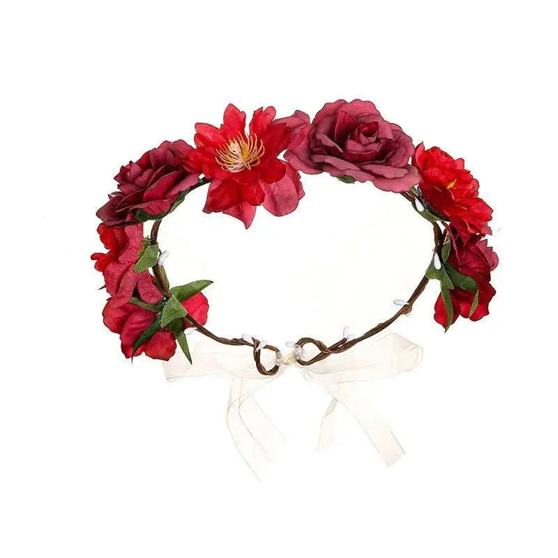 A fabric colorful rose flower garland hair accessory with red and burgundy artificial roses and green leaves tied by a white ribbon