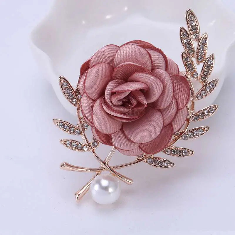 Delicate fabric flower lady temperamental pin with soft pink satin rose, gold metal leaves, clear crystals, and pearl drop
