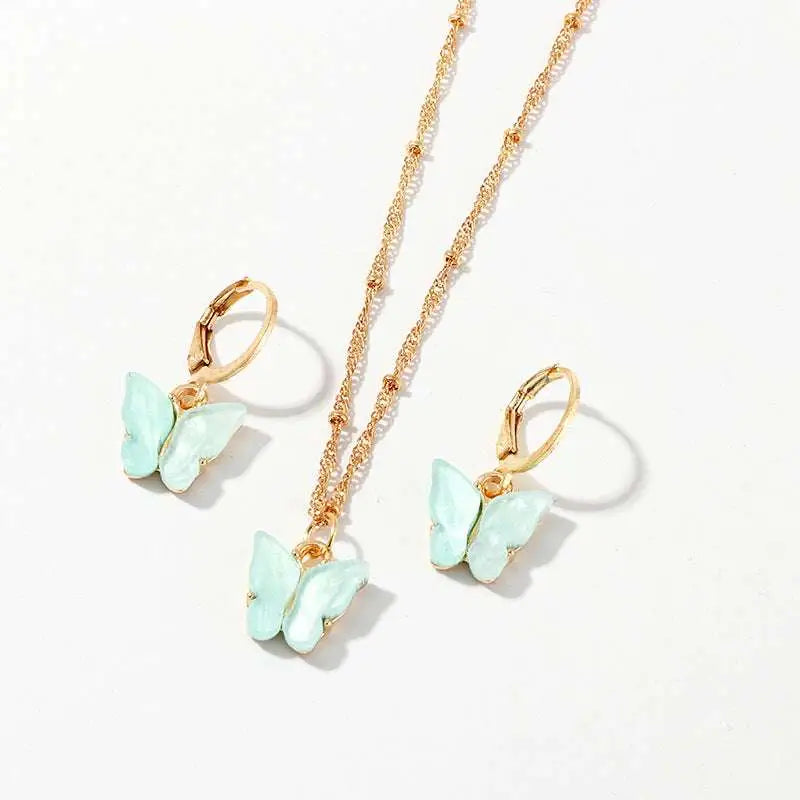 Gold-toned resin butterfly necklace and matching gold hoop earrings with light mint green enamel wings for creative fashion use
