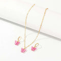 Fashion resin butterfly necklace and earring set featuring pink resin butterfly pendants with matching gold hoop accents