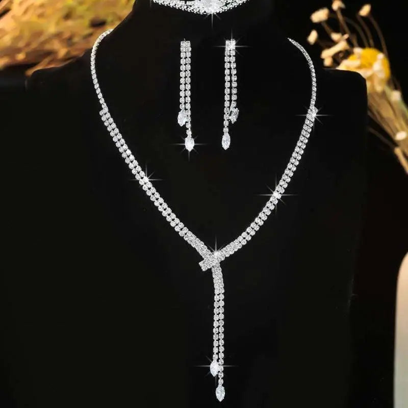 Silver rhinestone necklace featuring a sparkling v-shaped design with a delicate chain and teardrop pendant in necklace earring bracelet set