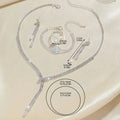 Silver rhinestone necklace earring bracelet set featuring delicate chain and intricate crystal detailing for bridal wear