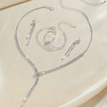 Silver rhinestone necklace with cascading design and dangling crystal teardrops in a necklace earring bracelet set