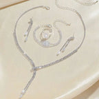 Silver rhinestone necklace with cascading design and dangling crystal teardrops in a necklace earring bracelet set