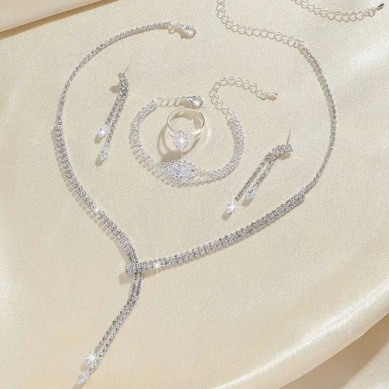 Silver rhinestone necklace with cascading design and dangling crystal teardrops in a necklace earring bracelet set