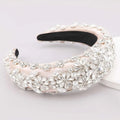 A blush pink satin pink floral headband adorned with delicate pink pearls and sparkling rhinestones for fashion use