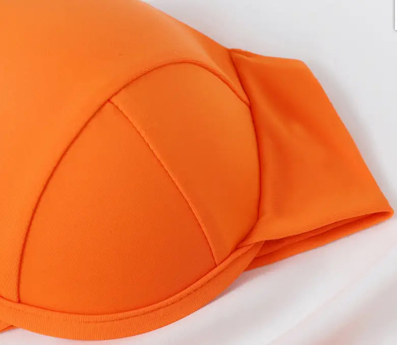 Bright orange strapless bra with smooth stretchy fabric and structured seams in an orange crisscross split bikini set.