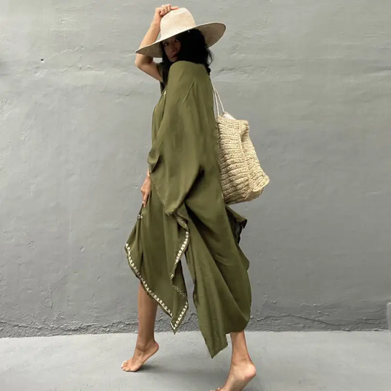 olive green flowing kaftan-style dress with draped design and white beaded trim along the hem paired with red rayon embroidered holiday sun protection cardigan.