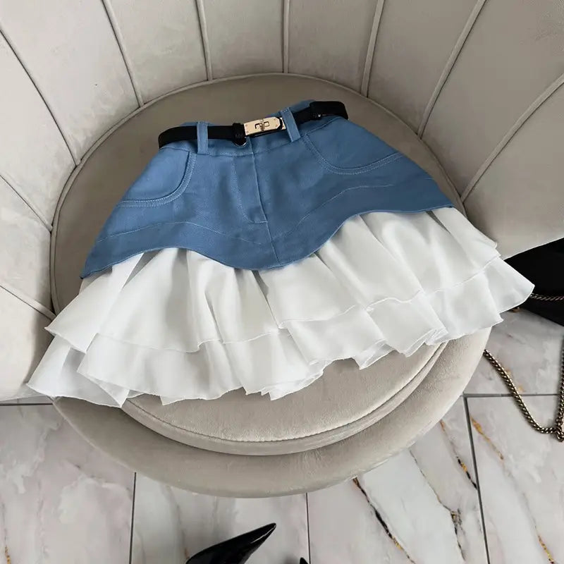 Denim and white ruffled high waist tiered skirt with a black belt and gold-tone buckle in a beige two tone style.