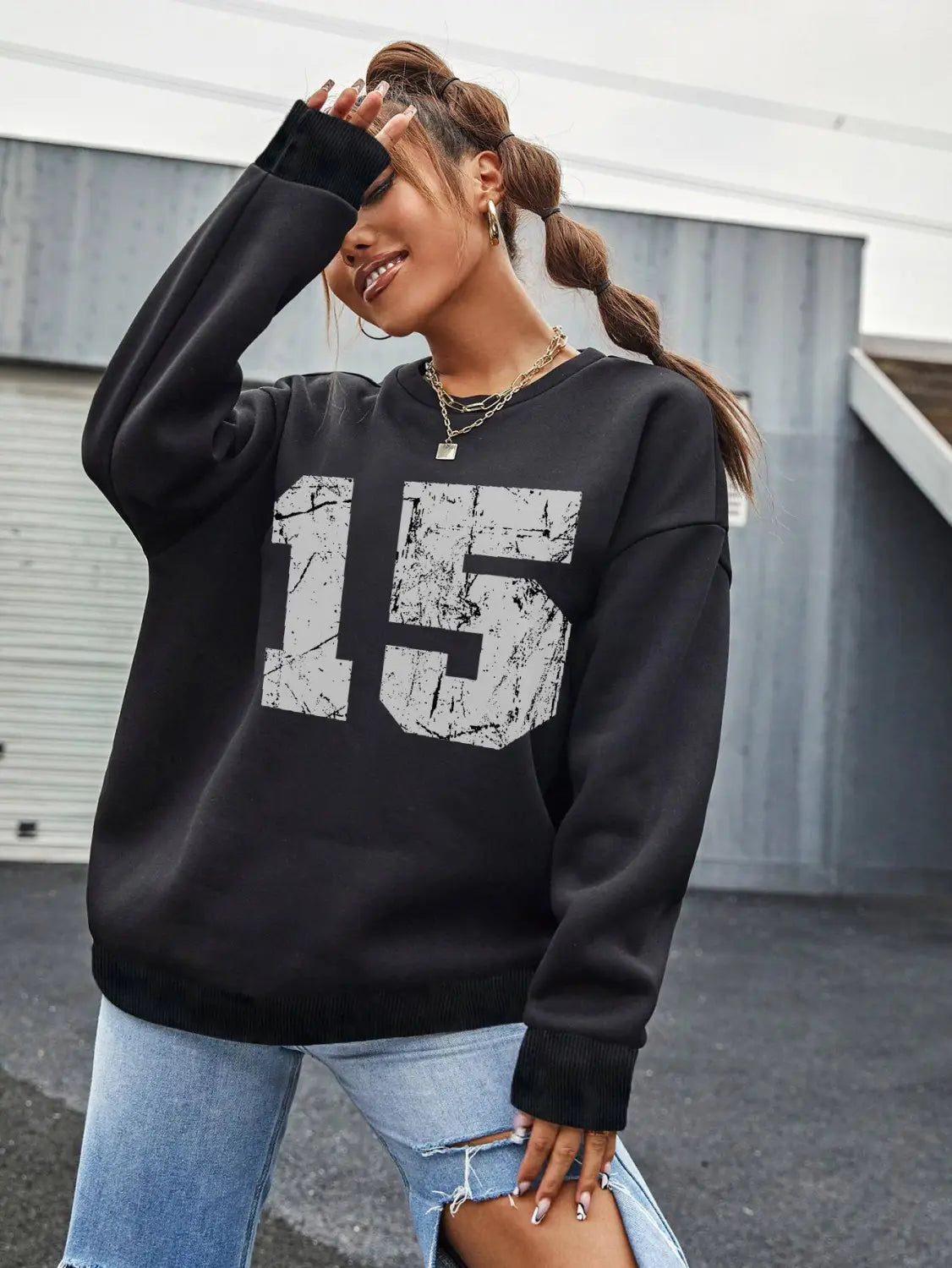 black crew neck sweatshirt featuring a distressed white number 15 graphic on the front