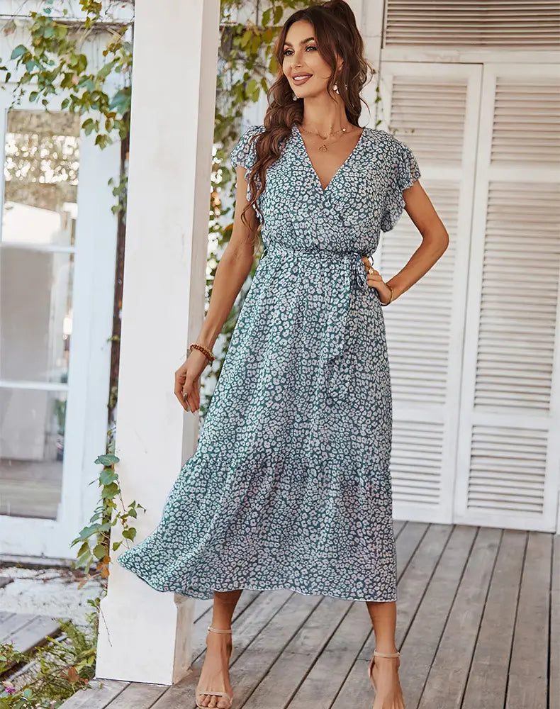 a flowing light blue and white floral print summer dress featuring ruffle cap sleeves and short flutter sleeves perfect for warm weather occasions