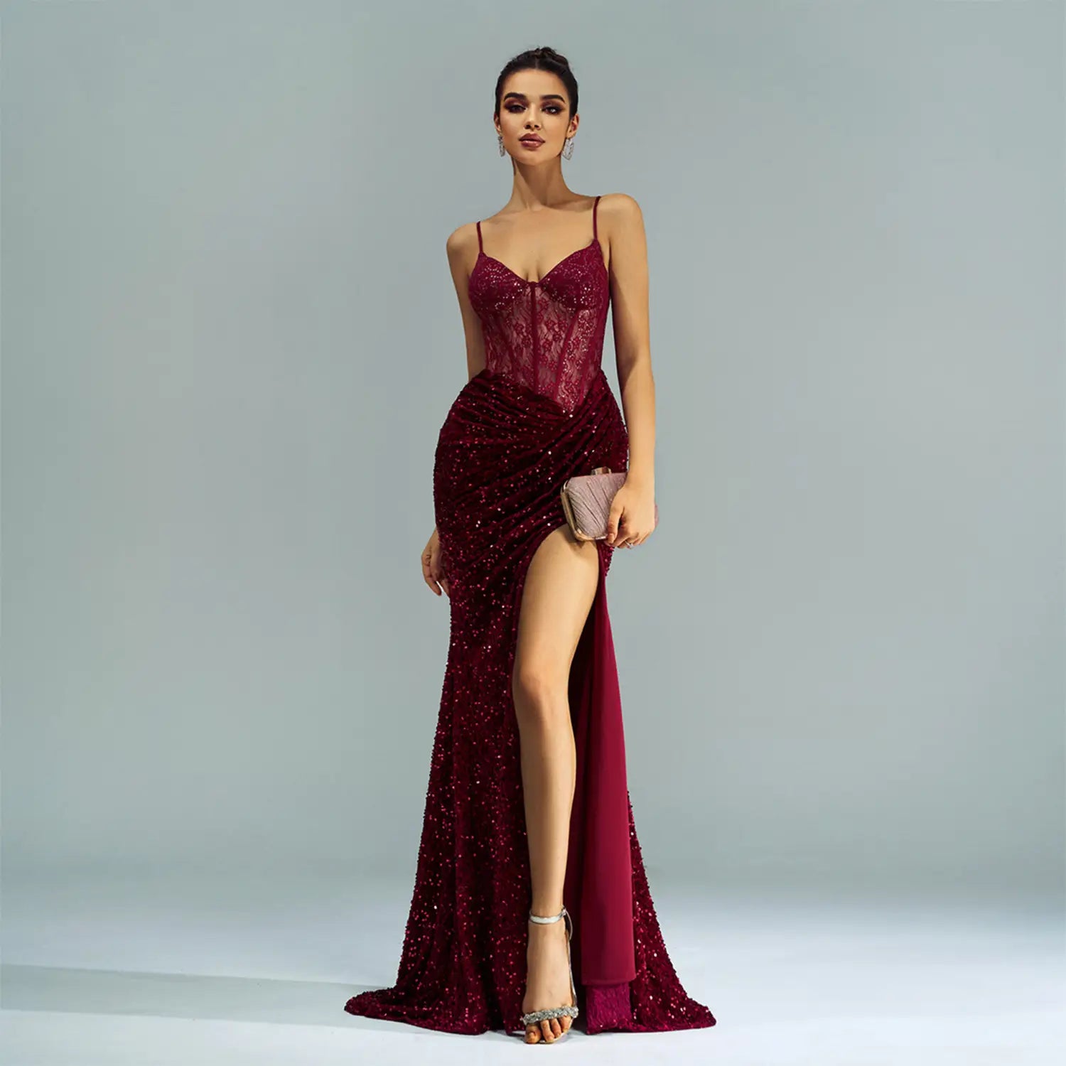 a shimmering burgundy sleeveless sequined high slit evening dress with a fitted bodice and spaghetti straps