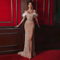 A shimmering champagne sequin evening dress with feather raglan large shoulder accents and a large slit sexy design