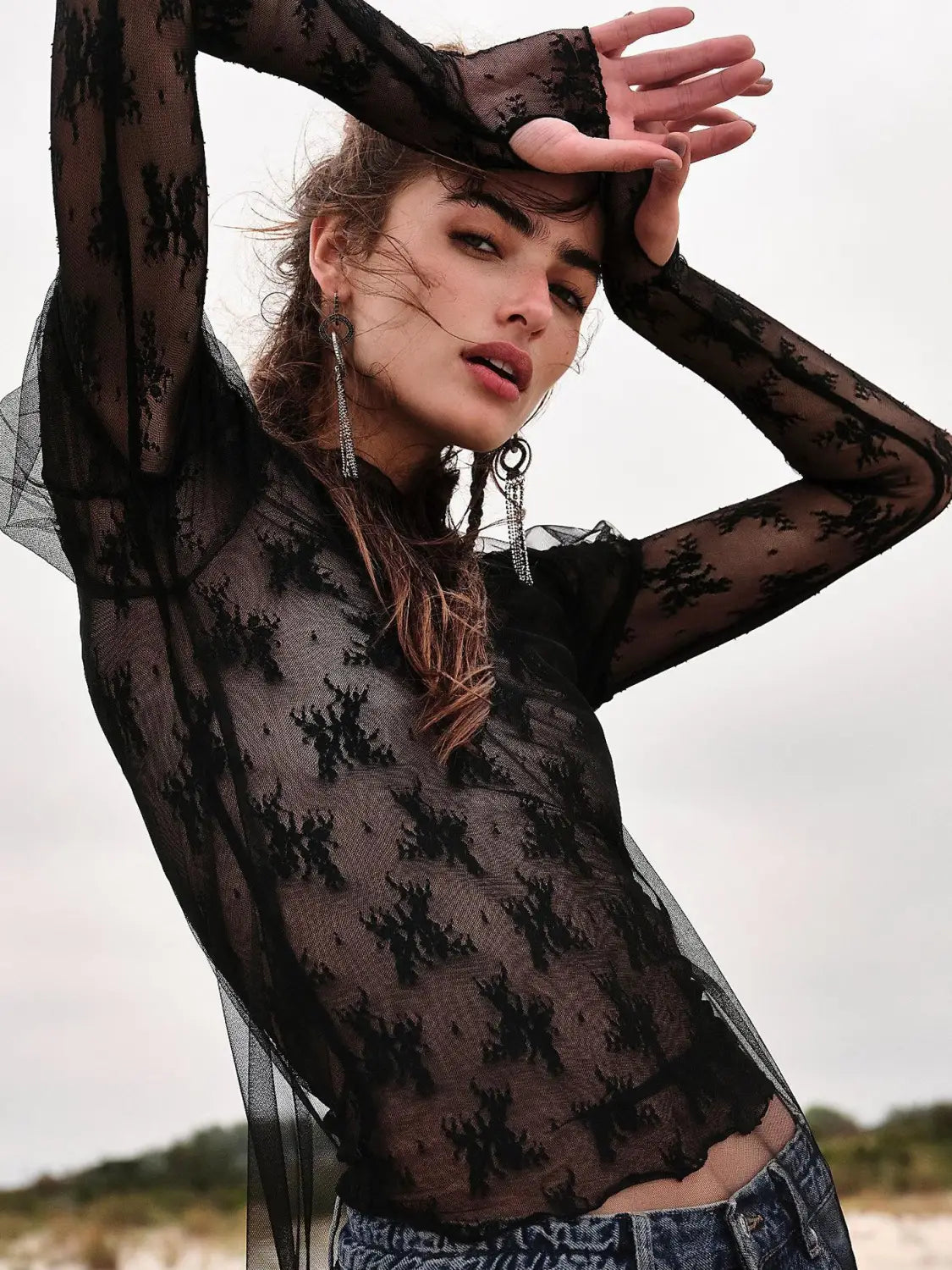 Black sheer lace long-sleeved women’s see-through lace top with a delicate floral mesh pattern.